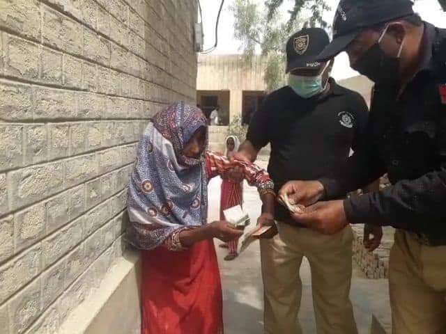 Viral photo shows a poor woman handing money over to policemen 